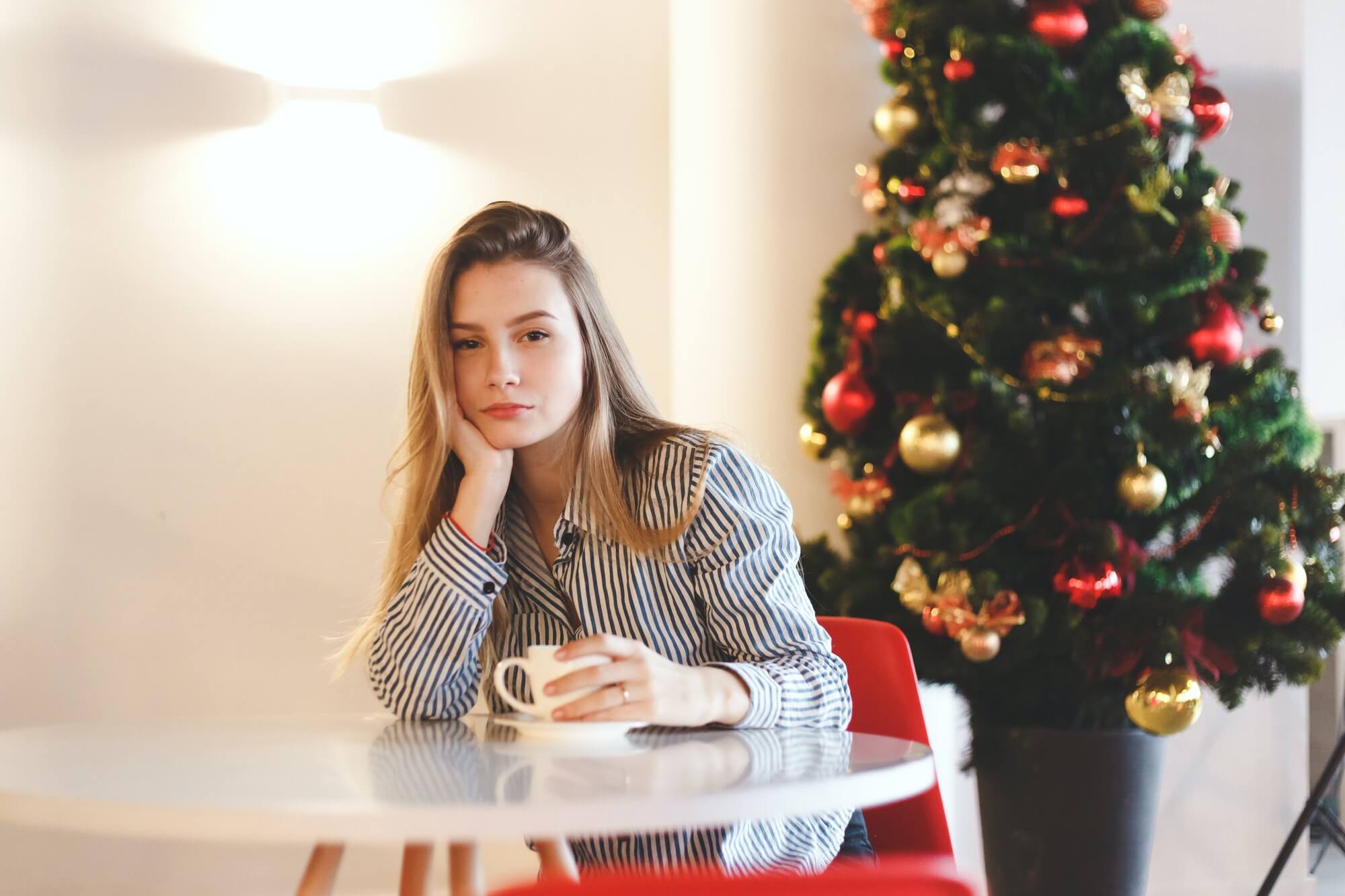 young-beautiful-woman-drinks-hot-coffee-in-cafe-with-christmas-tree-decorations-1.jpg